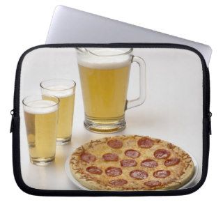Pitcher and two pints of beer beside pepperoni laptop computer sleeve