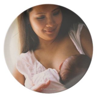 Mother breast feeding newborn plate