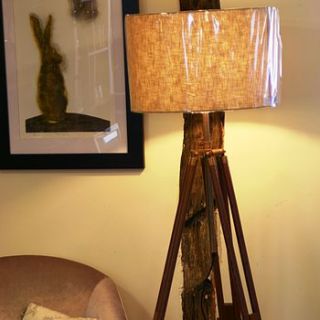 dark wood and brass tripod floor lamp by candle and blue