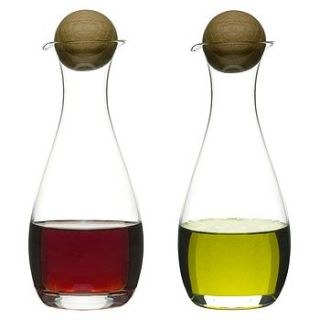 oil and vinegar bottles with oak stoppers by nest