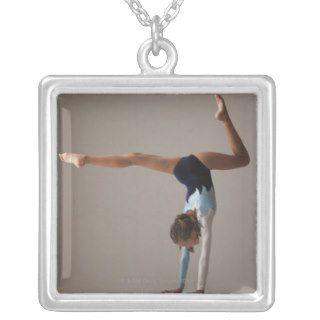 Female gymnast (12 13) performing handstand necklaces