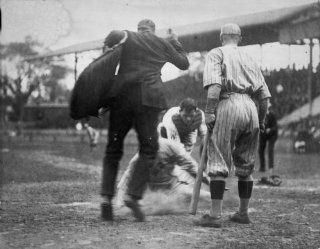 Umpire making the call on a man sliding into home plate during a baseball gam d1  