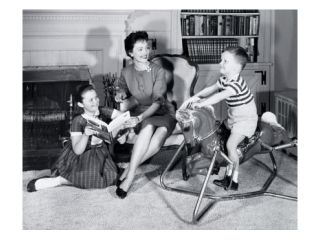 Side profile of a boy sitting on a rocking horse with his mother and sister sitting beside him Poster Print (18 x 24)